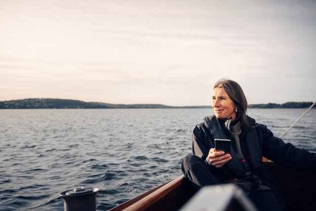 Woman sailing at sea with mobile SMALL